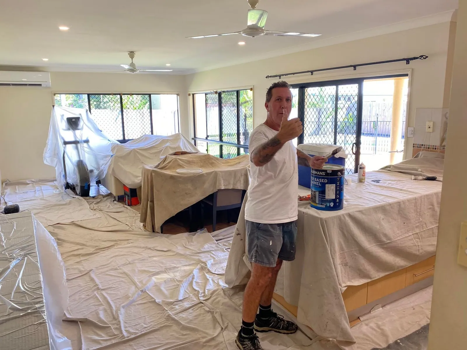 Painter holding a paintbrush in a prepared room ready for painting